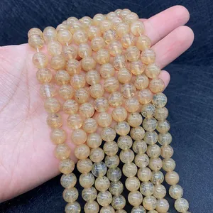 Macro shot of natural yellow rutilated quartz beads with golden needle inclusions