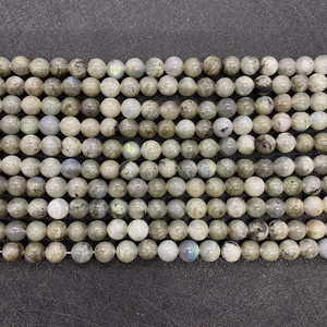 Dettaglio di perle tonde in labradorite naturale con riflessi blu e lampi di colore