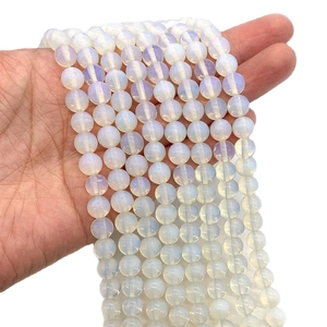 Strands of smooth opalite round beads showing soft blue sheen and milky white texture
