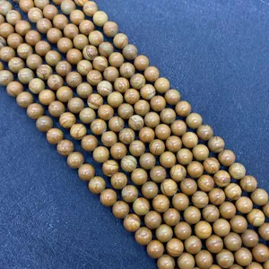 Dettaglio macro di perline di legno naturale giallo per gioielli e collane fai da te