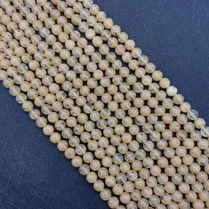 Macro view of natural yellow quartz beads showing clear golden rutile inclusions and texture