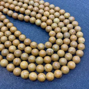 Dettaglio macro di perle in pietra naturale venata con trame marroni organiche naturali