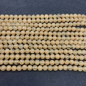 Macro view of natural yellow quartz beads with golden rutile inclusions and smooth finish