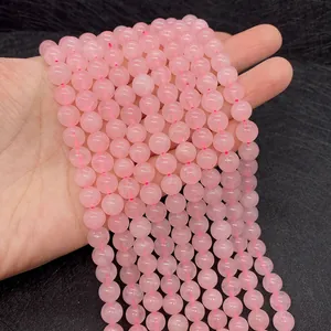 Macro view of polished pink rose quartz round beads with natural ice cracks for DIY jewelry