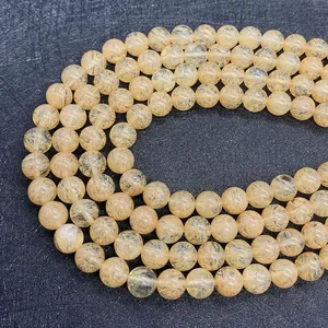 Macro view of natural yellow rutilated quartz beads showing golden silk hair inclusions