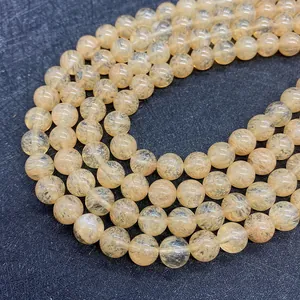 Macro shot of natural yellow rutilated quartz beads with dark needle-like inclusions