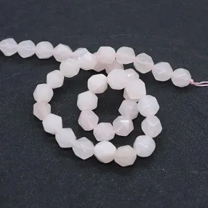 Macro detail of faceted rose quartz round beads with delicate light pink translucent texture