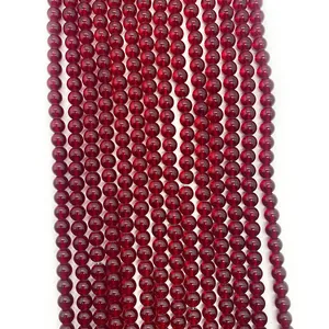 Macro shot of polished round dark red garnet beads showing smooth surface and transparency
