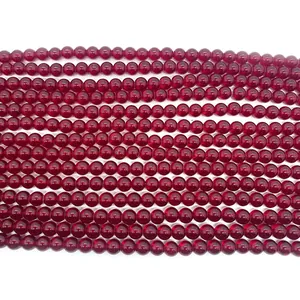 Macro shot of polished red garnet round beads for DIY jewelry making and necklace crafts
