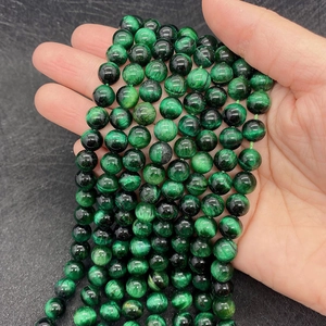 Close-up of natural green tiger eye beads with silky luster texture for DIY jewelry
