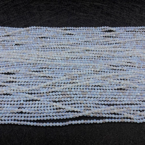 Dettaglio di perle di opale sfaccettate da 2 a 4mm con riflessi blu su uno sfondo scuro