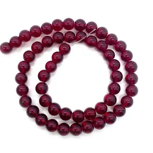 Macro detail of deep red garnet beads arranged in a double spiral on white background