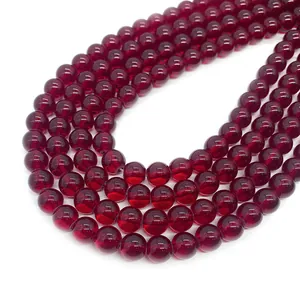 Polished dark red garnet round beads for DIY jewelry making displayed on white background