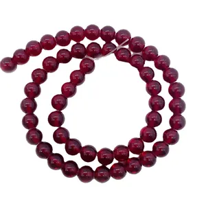 Polished dark red garnet round beads for DIY jewelry making on white background