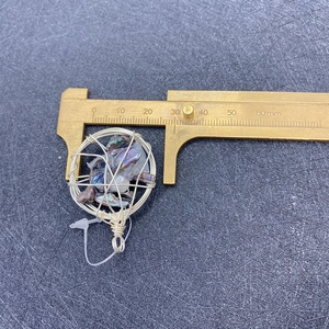 Messen eines 30mm handgefertigten Drahtanhängers mit unregelmäßiger Muschel-Einlage