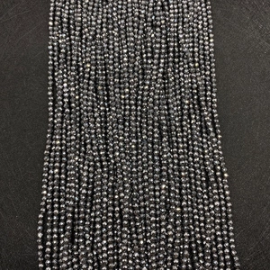 Macro shot of 2-4mm faceted hematite stone beads with metallic finish for jewelry making