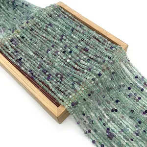 Faceted natural fluorite 2mm to 4mm beads in green and purple hues on wooden tray