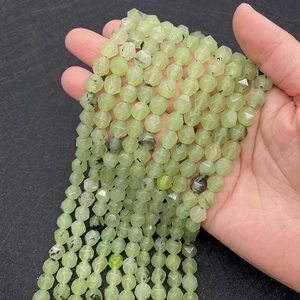 Close-up of faceted natural green prehnite beads with inclusions for DIY jewelry making