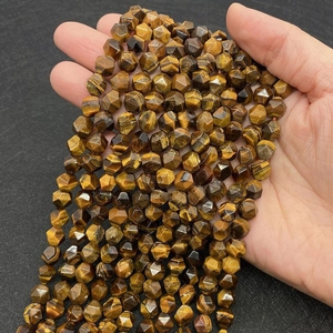 Makroaufnahme von facettierten Tigerauge-Edelsteinperlen mit goldbraunen Streifen und Glanz