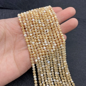 Macro shot of 2-4mm faceted round cream beads with iridescent luster for DIY jewelry making