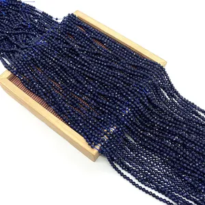 Perles facettées en pierre de sable bleu 2-4mm pour bijoux DIY disposées dans un plateau bois