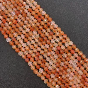 Dettaglio macro di perline di corniola sfaccettate in arancio-rosso per gioielli fai-da-te