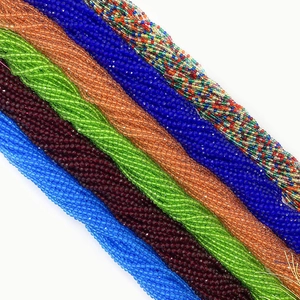 Detalle macro de hilos de cuentas de vidrio talladas de 2mm multicolores para joyería