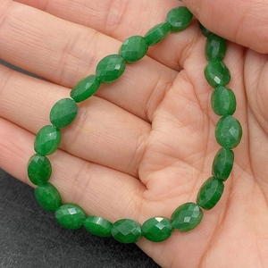 Macro-opname van groene gefacetteerde ovale kristallen kralen voor het maken van sieraden