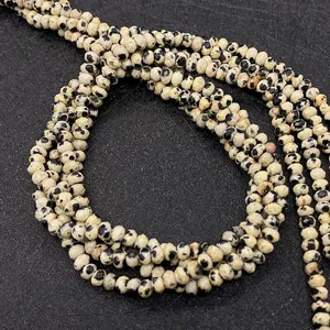 Macro shot of faceted Dalmatian Jasper beads in beige with natural black spots for DIY jewelry