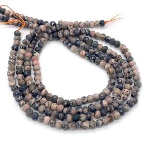Detail of faceted rhodonite loose beads showing natural pink and black stone textures