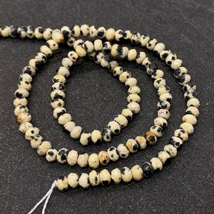 Macro shot of faceted Dalmatian Jasper beads showing natural black spots on white base