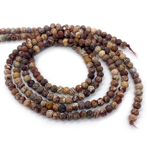 Close-up of faceted natural African pine stone beads with unique earthy stripe textures