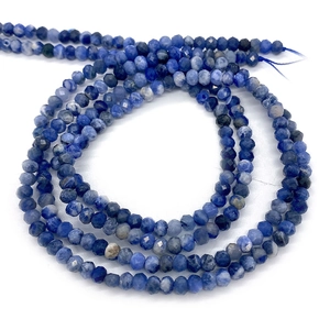 Macro shot of natural faceted blue sodalite beads showing fine texture and reflective surface