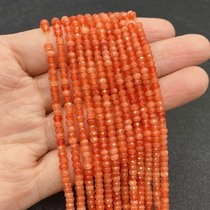 Detalle macro de cuentas de ágata naranja facetadas de 2-3mm con cortes de precisión