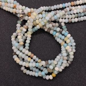 Primer plano de cuentas de piedra natural facetadas en azul y blanco con corte de lujo