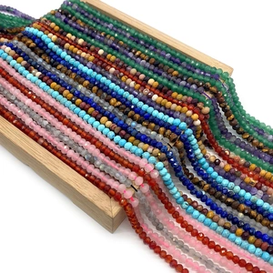 Faceted natural gemstone round beads including amethyst and tiger eye on wooden stand