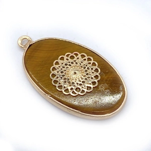 Detailopname van de ovale tijgeroog hanger met goudkleurige mandala filigraan inleg