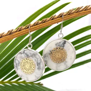 Ohrhänger aus weißem Türkis mit goldenem Mandala-Blumenmuster und silberner Fassung