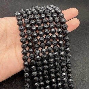 Close-up of polished black turquoise beads with white spiderweb patterns for DIY jewelry