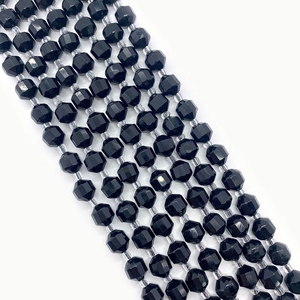 Macro detail of faceted black natural stone beads with polished diamond cut surfaces