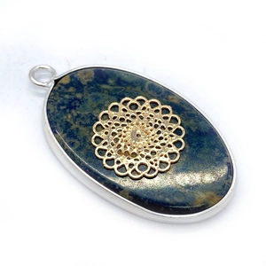 Detail van ovale natuurstenen hanger met gouden mandala-inleg en een zilveren randafwerking