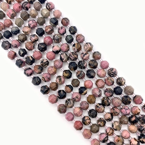 Detailed macro shot of faceted natural Rhodonite gemstone beads with pink and black patterns