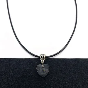 Macro shot of faceted heart-shaped clear crystal pendant with silver decorative bail