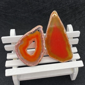 Detailed view of two natural agate pendants in irregular ring and teardrop shapes