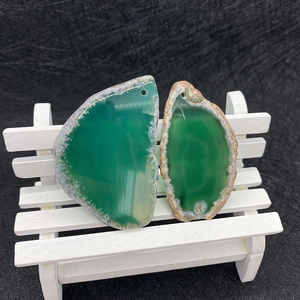 Detail showing translucent green natural agate pendants with unique banded textures and pre-drilled holes