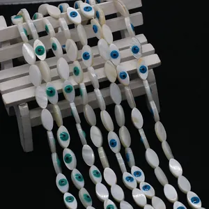 Macro detail of natural shell marquise beads featuring a colorful evil eye pattern