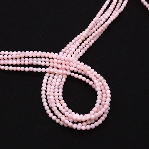 Macro-opname van 4mm gepolijste roze natuurlijke schelpkralen voor DIY-sieraden