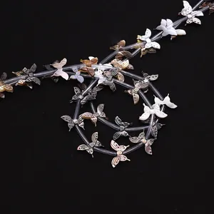 Detail of natural black shell butterfly beads with iridescent luster on black background