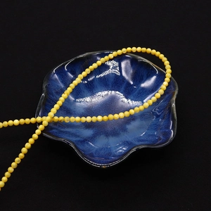 Natuurlijke gele zoetwaterschelp ronde kralen 2mm-4mm in een kom voor doe-het-zelf sieraden