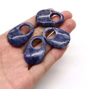 Close-up of four polished blue sodalite natural stone teardrop pendants with large holes